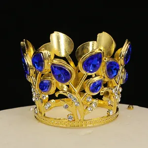 Macro shot of gold mini crown with navy blue gems and rhinestones for cake decoration