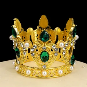Detailed close-up of golden vintage crown with green gemstones and pearls on display