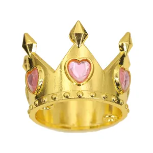 Makroaufnahme Goldener Kronenring mit drei rosa Herz-Edelsteinen und geprägten Details