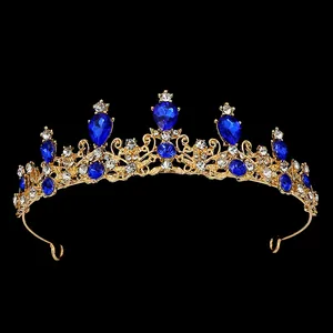 Détail de diadème de mariée doré avec strass bleus en goutte et motifs évidés complexes