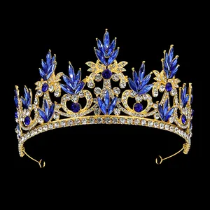 Détail de la couronne baroque dorée avec strass bleu foncé sur un fond noir intense