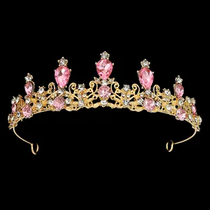 Détails d'un diadème de mariée doré avec cristaux roses et motifs en métal ajouré
