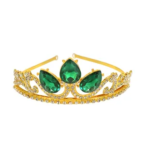Close-up of gold crown with large green teardrop gems and small white rhinestones