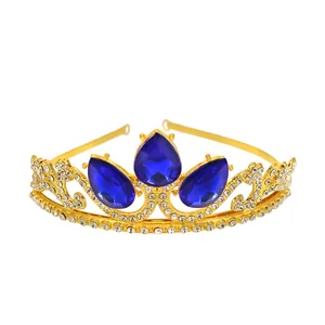 Close-up of golden crown headband featuring large blue teardrop rhinestones and carvings