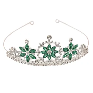 Detailed view of silver crown featuring green marquise gems and white rhinestones