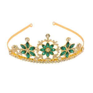 Detail of golden snowflake tiara featuring green marquise gems and white rhinestones