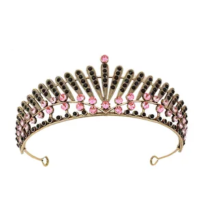 Close-up of vintage bridal crown with pink and black rhinestones on antique gold frame