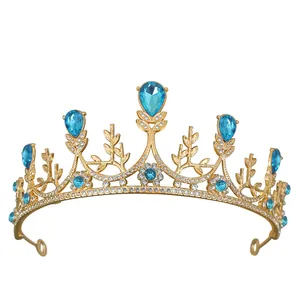 Dettaglio di tiara dorata con gemme blu a goccia e motivi a foglia intagliati