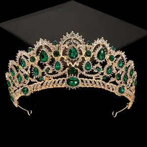 Luxurious gold crown with emerald green teardrop gems and crystals on a black background