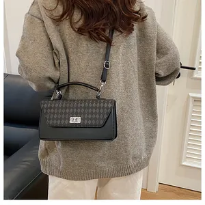 Vue arrière du petit sac vintage noir avec motif losange et fermoir rotatif argenté