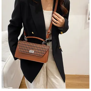 Détail du motif à carreaux marron sur un sac à bandoulière en similicuir avec boucle