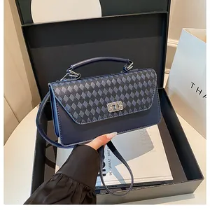 Détail du sac bandoulière vintage bleu foncé avec texture losange et fermoir argenté