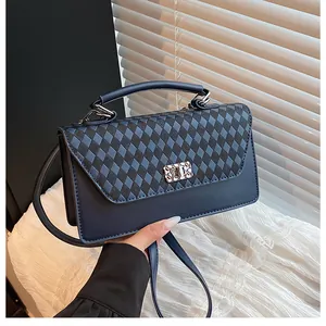 Détail du sac à bandoulière bleu foncé avec rabat à carreaux et fermoir argenté chic