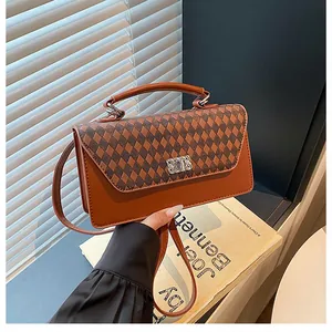 Détail macro du sac à main vintage en cuir marron avec motif de losanges et boucle dorée