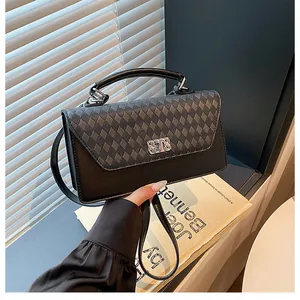 Détail du sac à main noir avec motif losanges et fermoir en métal argenté en similicuir