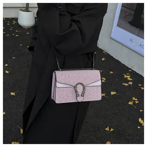 Detail view of the pink leopard print crossbody bag featuring a silver tiger head buckle