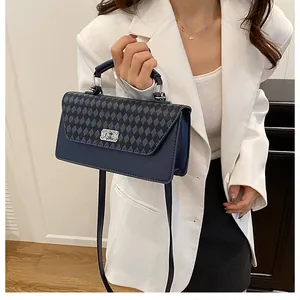 Détail du sac à main bleu marine à carreaux avec fermoir métal et poignée solide