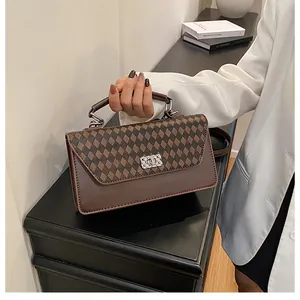 Détail du sac à bandoulière marron vintage avec motif en losanges et fermoir en métal argenté