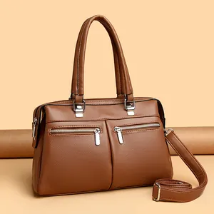 Caramel brown pebbled leather handbag with double front zippers and adjustable strap