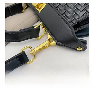 Detail of black woven shoulder bag featuring premium gold metal hooks and D-ring hardware