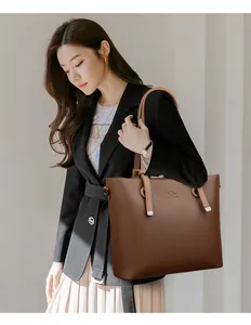Détail d'un sac cabas en cuir grainé marron foncé avec logo kangourou et longue bandoulière