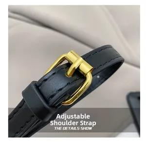 Close-up of adjustable black leather shoulder strap with gold metal buckle detail