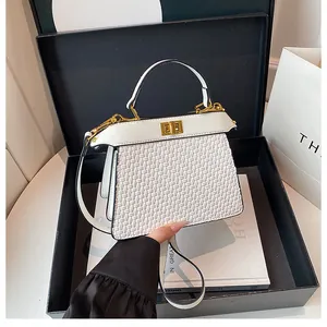 Detail of white crocodile textured handbag in a black gift box with gold metal clasp