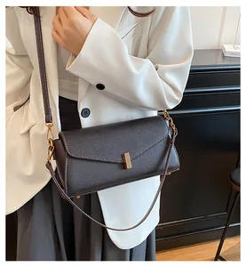 Detail of vintage textured leather crossbody bag with elegant gold metal buckle