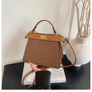 Detail of vintage brown woven leather handbag with golden twist lock and top handle