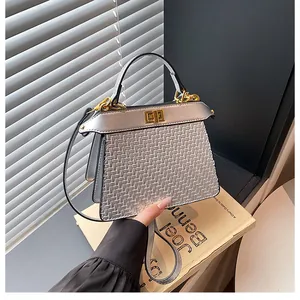 Close-up of silver woven texture leather bag with metallic finish and gold twist lock