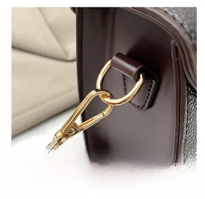 Macro shot of high-quality gold metal hook and dark brown lychee pattern leather strap