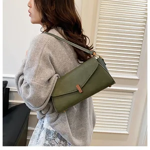 Detail of dark green rectangle bag showing lychee pattern leather and metal clasp