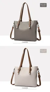 Détail de sacs cabas en cuir grainé gris foncé et gris clair avec des anses brunes