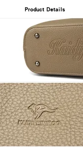 Détail du sac à main taupe avec texture cuir, clous de protection et logo gaufré