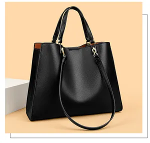Details der schwarzen Leder-Tote mit Kontrastfutter und goldfarbenen Metallteilen