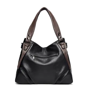 Close-up of textured black PU leather bag with brown handles and metal zipper detail