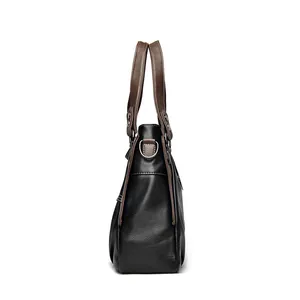 Detail of color-blocked leather tote bag with silver metal ring and pebbled texture