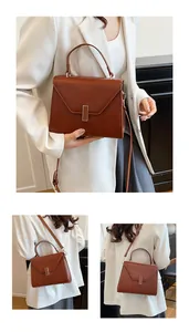Detail of caramel pebbled leather tote with gold buckle and adjustable shoulder strap