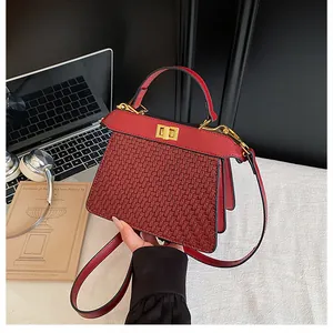 Detailed view of red woven texture bag with gold twist lock and accordion fold sides