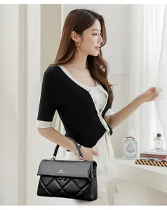 Close-up of black quilted leather handbag with brand logo and soft texture detail