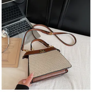 Detail of the brown leather and beige woven texture on the tote bag with golden twist lock
