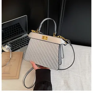 Detail of silver woven texture handbag with metal turn-lock and elegant top handle