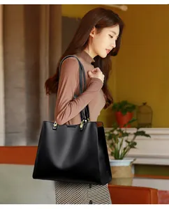 Nahaufnahme der schwarzen Leder-Tote-Bag mit Litschi-Textur und goldenen Schnallen