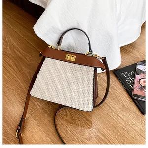 Detail of retro woven white leather texture and brown handle on a stylish handbag