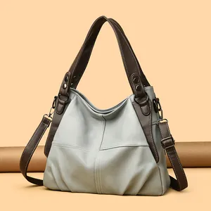 Detail of grey-blue pebble leather tote with contrast stitching and vintage hardware