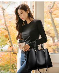Detailansicht schwarze Shopper-Tasche aus strukturiertem Leder mit goldener Verzierung