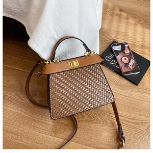 Detail of brown woven leather bag with gold turn-lock and vintage cross-weave texture