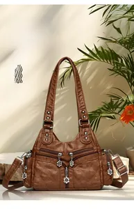 Détail du sac en cuir marron vintage avec motif matelassé et breloque fleurie