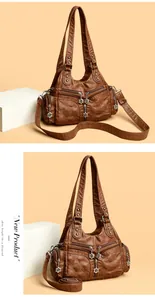 Détail du sac vintage en cuir souple marron avec motif matelassé et zips floraux
