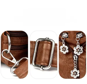 Vue détaillée des fermetures éclair fleur argentées et boucles sur sac en cuir